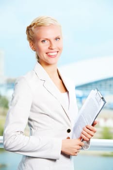 Portrait of elegant businesswoman with clipboard looking at camera