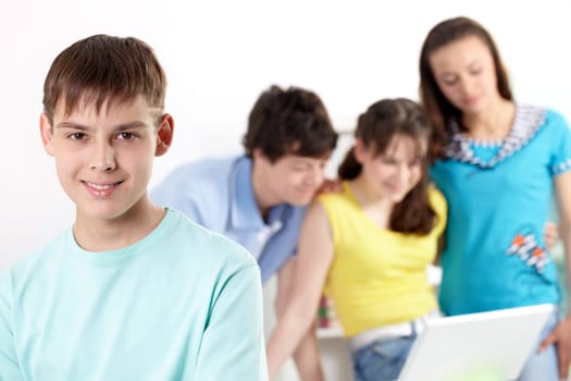 Teenage boy looking at camera and smiling against his friends