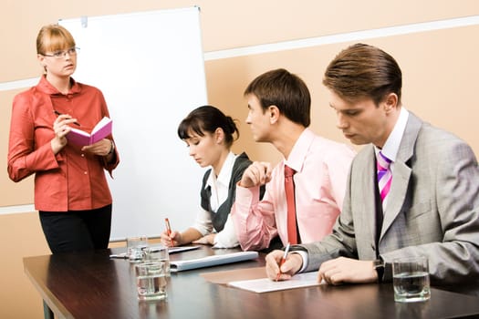 Image of smart teacher looking at businessman and speaking to him in workshop