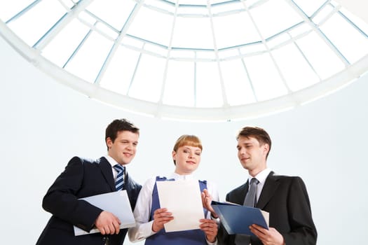 Photo of confident business people looking at paper in female hand at meeting