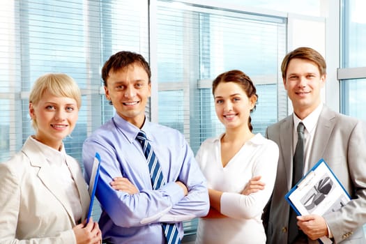 Portrait of smart business people standing next to each other and looking at camera