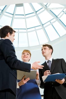 Image of smart professional explaining something to his colleagues at meeting
