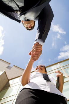 Below angle of successful partners handshaking after striking deal