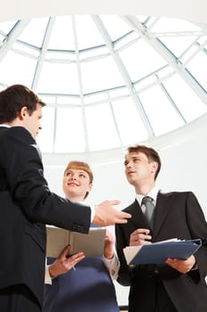 Image of smart professional explaining something to his colleagues at meeting