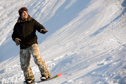 Photo of cheerful man standing on snowboard at winter resort
