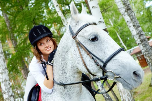 Image of happy female jockey on purebred horse outdoors