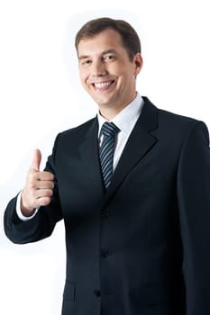 Vertical image of successful businessman looking at camera and showing thumb up
