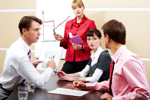 Image of smart teacher looking at students while explaining new topic