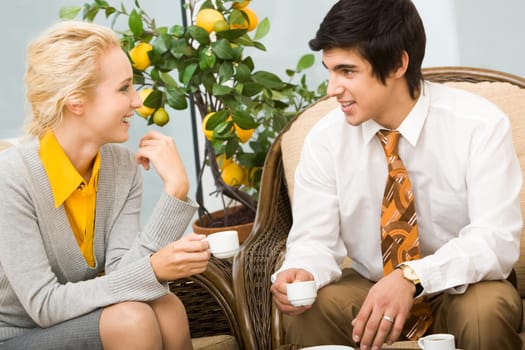 Portrait of smart colleagues having conversation in office during coffee break