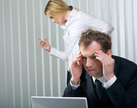Photo of stressed businessman touching his head with secretary at background