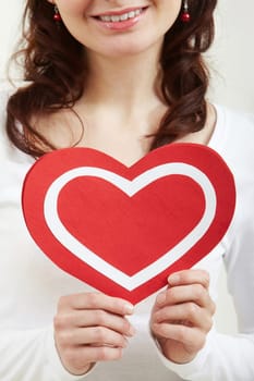 Close-up of female hands holding paper heart