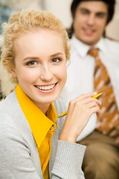 Portrait of blond woman looking at camera with smile on background of man