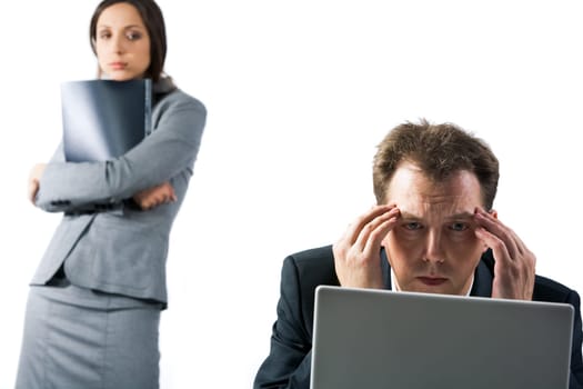 Photo of stressed businessman looking at laptop screen with troubled female at background