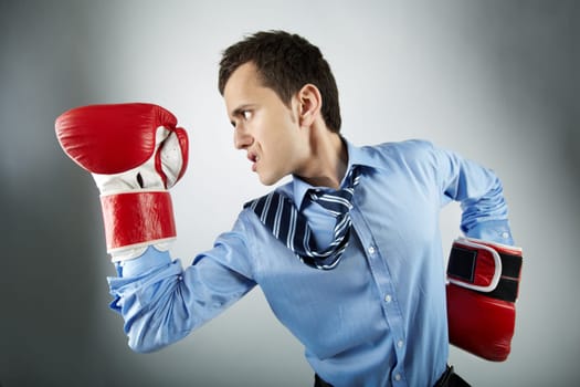 Portrait of businessman in boxing gloves posing in front of camera