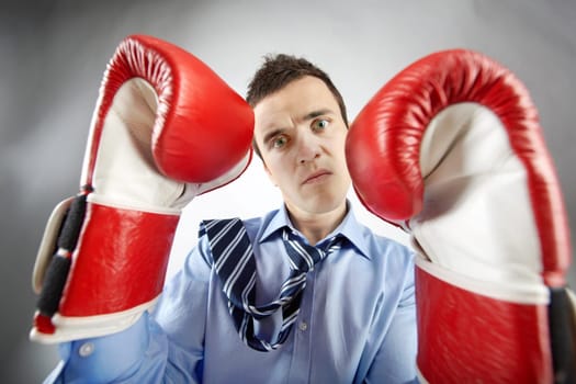 Portrait of businessman in boxing gloves posing in front of camera