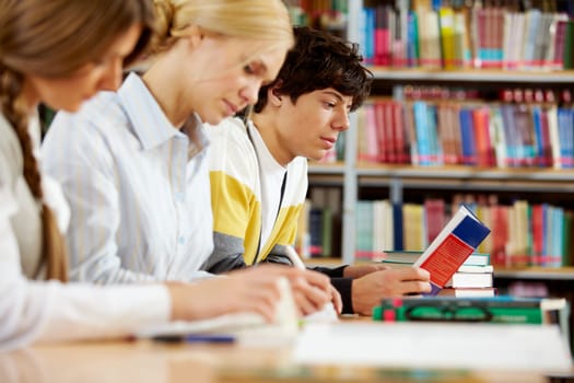 Portrait of serious groupmates preparing lessons in college library