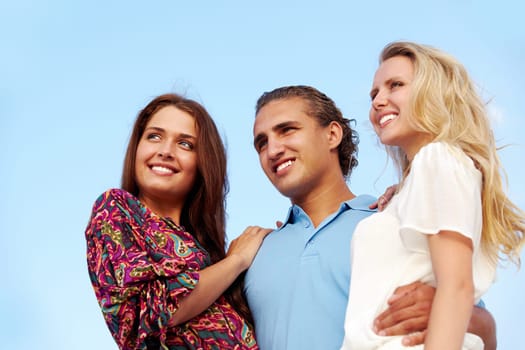 Portrait of happy girls and guy looking forward outdoors