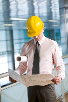 Portrait of confident foreman in helmet learning blueprint