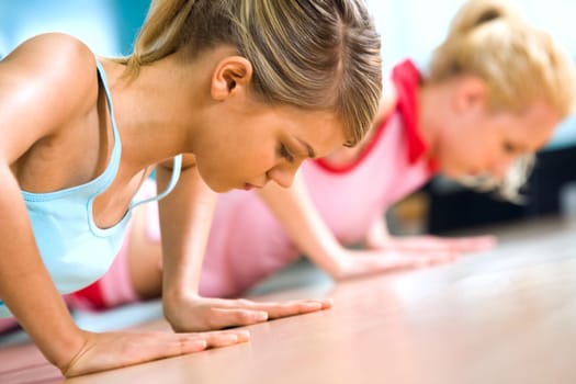 Photo of young girl doing difficult exercise for arm biceps on the floor