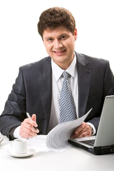 Portrait of confident businessman sitting at workplace and looking at camera