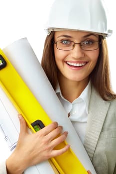 Portrait of smiling businesswoman in helmet holding rolled blueprints