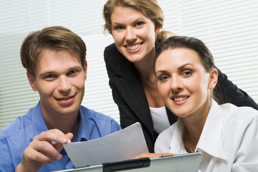 Portrait of three business people looking at camera in a working environment