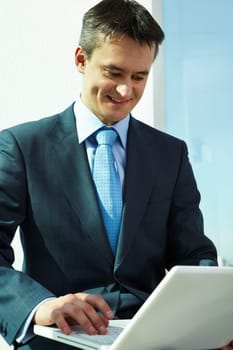 Portrait of confident man working with laptop