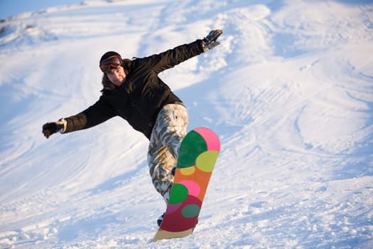 Image of brave man practicing snowboarding in winter