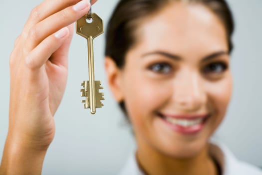 Smiling business woman is holding the key