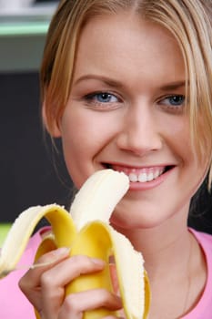 Portrait of young pretty woman eating the banana