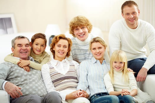 Portrait of senior and young couples with their children looking at camera at home