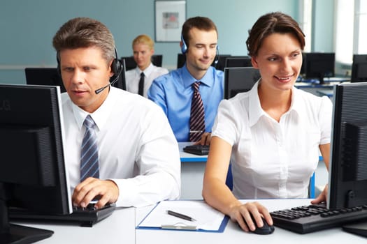 Four business colleagues sitting at their computer and working in office