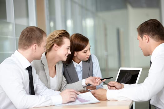 A business team of four sitting at table and planning work