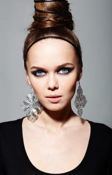 Gorgeous woman with fantasy earrings looking at camera