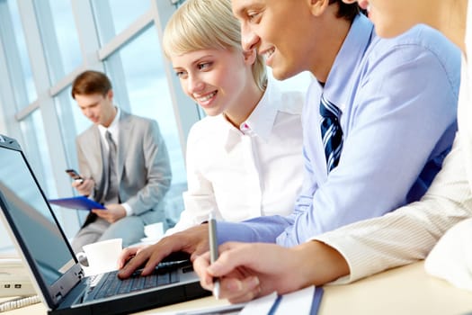 Portrait of executive employees looking at laptop monitor in office and interacting