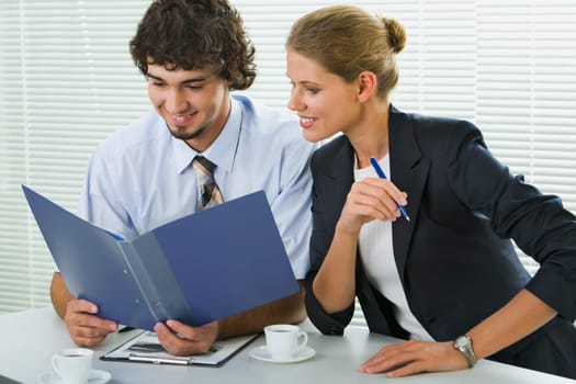 Portrait of businesspeople sitting at the table and reading paperwork