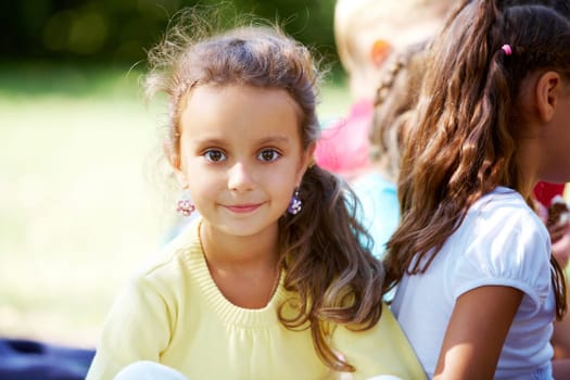 Portrait of happy girl looking at camera with her friends near by
