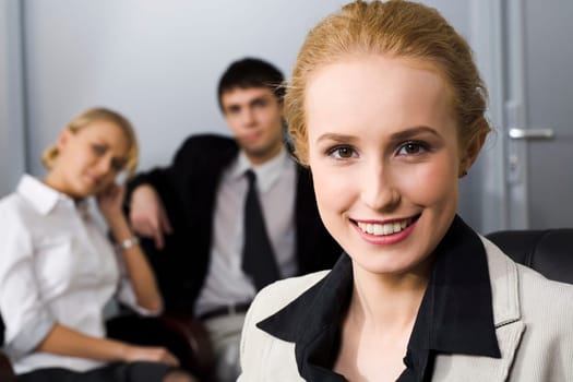 Portrait of smiling businesswoman and two her partners on the background