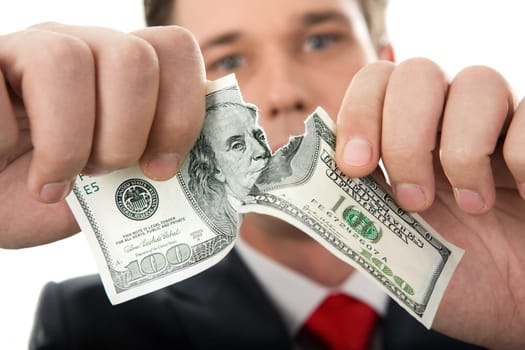 Close-up of human hands tearing hundred-dollar banknote