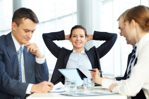A young businesswoman relaxing against her colleagues