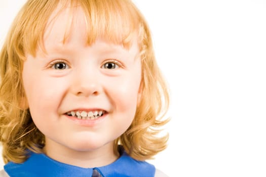 Portrait of little redhead girl happily smiling and looking at camera