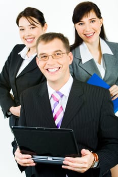 Portrait of three confident business partners looking at camera with smiles with leader holding laptop in front