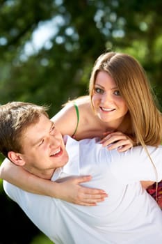 Photo of happy girl embracing her boyfriend and looking at camera