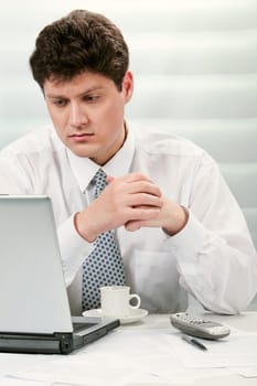 Portrait of smart businessman looking at laptop monitor seriously