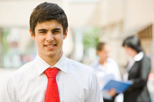 Portrait of handsome employer smiling at camera in working environment