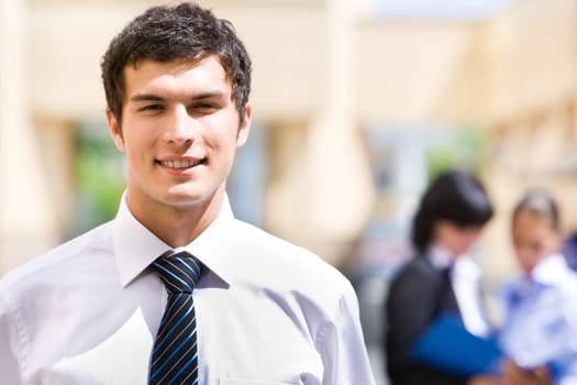Portrait of handsome employer looking at camera with smile in working environment