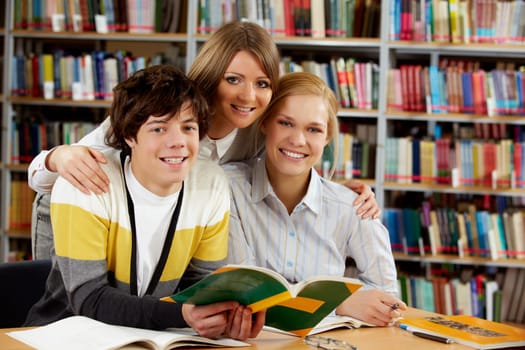 Portrait of happy friends looking at camera in library