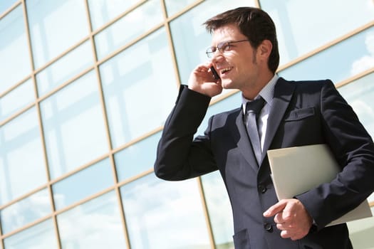 Photo of handsome employer speaking on mobile phone