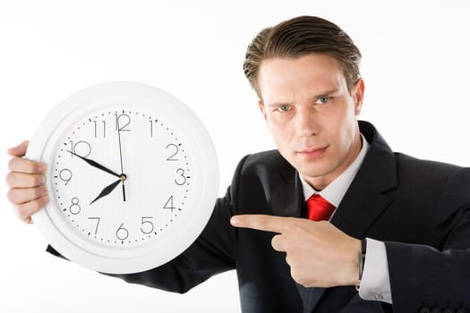 Portrait of angry boss holding clock in hands and pointing at it