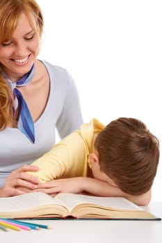 Portrait of little boy turning page of book with mother near by